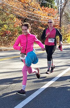 At the 16th annual Camy 5K Run, Morgan Gariepy (109), Stephanie Lee (121), Eileen Heffernan, near the finish at the Walpole Italian-American Club.