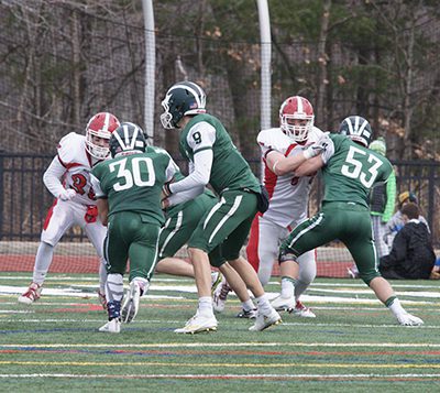 Quarterback Reed Wilson (9) hands the ball off on a read option to running back Nick Abbatangelo (30). Photo by Paul Goldburg