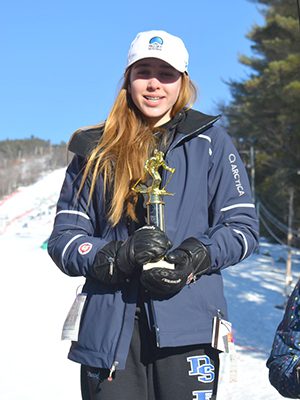 Addie Atwood poses with her championship trophy after taking home first place in the U14 girls giant slalom on Saturday.
