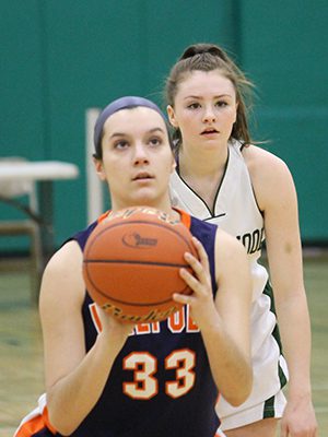 Walpole’s Melanie Weber (15) looks on as Walpole’s Catherine Alex (33) puts up a free throw attempt. Photo by Michael Flanagan
