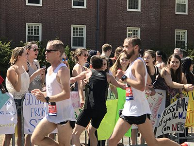 A marathoner stops for a quick kiss at the Wellesley Scream Tunnel before heading off on the final 13.1 miles of his journey. Photos by Lisa Moore