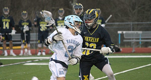 Medfield’s Jack Fitzgerald (21) fights his way through a stick check late in the first quarter. Photos by Michael Flanagan