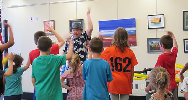 Jungle Jim leads his young audience in a stretch before he begins his performance. Photos by Gabe Stern