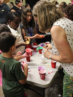Nancy Tegeler teaches the children how to make slime.  Photos by Peter Kougias