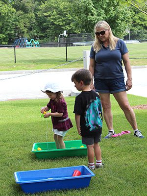 Twins, Jack and Miles McCarthy (4), and Jane Saulnier (2) play outdoors at the Westwood Public Library. Photos by Laura Drinan