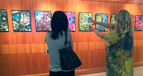Seamon eagerly explains her inspiration for the photographs to a library patron. Photo by Mary Kate Nolan