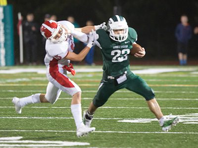 Westwood wideout Sean Gallagher (23) fights off a Holliston defender with a stiff arm during the Wolverines’ 41-7 defeat on Friday night.