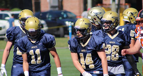 Junior defensive back Garrett Hirsch (11) is given praise by teammates James Jourdan (44) and Mike D’Alleva (28) following a tackle for loss late in the first half.