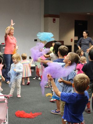 Youths at the Wellesley Free Library toss scarves in the air as they dance at the “Sing and Swing” event.