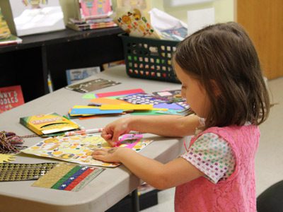 Five-year-old Shira decorates her own bookmark at the Dover Town Library’s open craft event, where children were invited to push their creativity to the limits with an assortment of materials from the library’s craft closet.