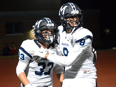 Running back and senior captain Mason Giunta (33) celebrates a first quarter touchdown run with teammate Jake Dubbs (8) during Medfield’s 34-14 season-opening win at Dedham on Friday. Photos by Lizzy Collotta