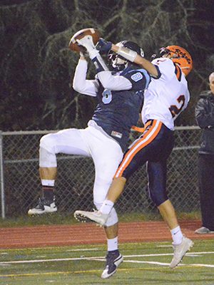 Medfield wideout Jake Dubbs (8) goes up and battles with Walpole defensive back Chase Conrad (2) for a 50/50 ball late in the second half of Friday night’s thrilling 36-30 victory by the Warriors.... 			
			</div data-eio=