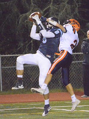 Medfield wideout Jake Dubbs (8) goes up and battles with Walpole defensive back Chase Conrad (2) for a 50/50 ball late in the second half of Friday night’s thrilling 36-30 victory by the Warriors. Photos by Lizzy Collotta