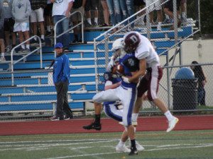 Spectators watch, mesmerized, as Junior cornerback Timothy Polk (4) fights off a Dedham wideout and comes down with an interception midway through the first quarter.
