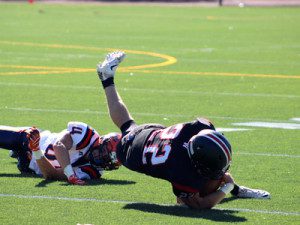 Walpole defensive end Kyle Smith (44) trips up Wellesley running back Justin Lindquist (22) early in the third quarter.