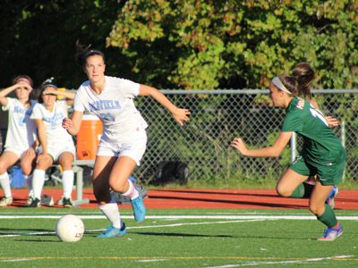 Medfield senior captain Maggie McCarthy (21) reads the field before making a cross midway through the first half. Photos by Michael Flanagan