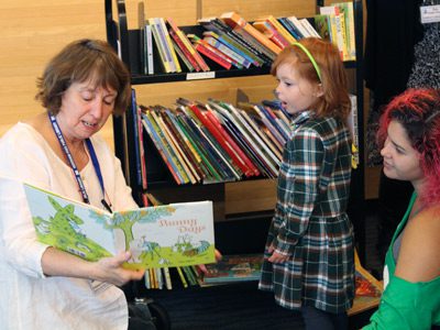 Needham Children’s librarian, Elise, shows a young girl ‘Bunny Days’ as a potential book to take home and keep as a reward for being a part of ‘The Big Read.’