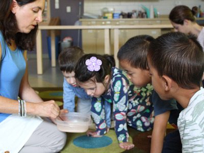 Preschoolers watch Sheryl make designs in a Zen garden before raking through the sand themselves at the Westwood Library’s mindfulness workshop.