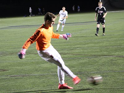 Wellesley goalkeeper Anders Pineau (pictured in orange) boots away a loose ball late in the first half.