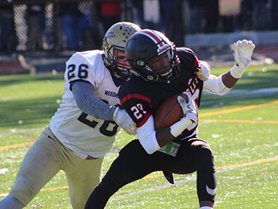 Needham’s John Marshall (26) attempts to corral Wellesley’s D’Aunte Moore (29) on a second quarter punt return. Photos by Michael Flanagan
