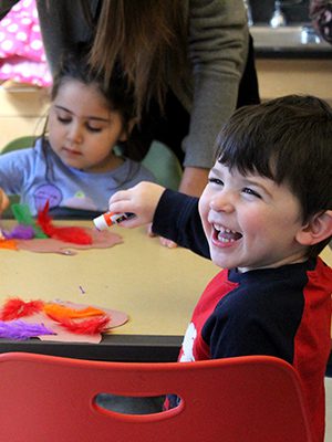 Children at the Walpole Public Library enjoy a feather gluing craft after playing with a parachute. Photos by Laura Drinan