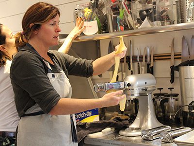 Meg Tallon demonstrates how to use the KitchenAid pasta attachment at the Dover and Westwood COA’s cooking class. Photos by Laura Drinan