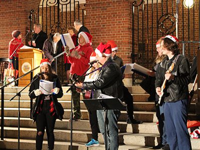 Needham’s Plugged In perform a variety of holiday carols at the annual Blue Tree lighting on town common. Photos by Laura Drinan