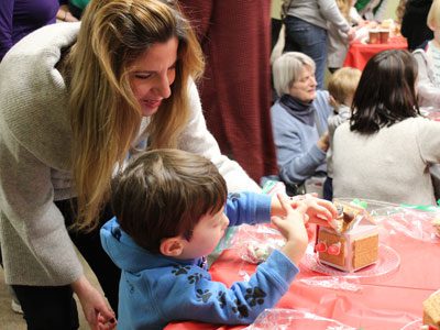 Four-year-old Carter Verni adds some candy to his gingerbread house at the Dover Library’s decorating event.
