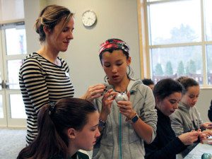 Children’s Librarian, Lizzy McGovern, enjoys one student’s completed unicorn ornament at the weekly ‘Fri-YAY’ program.