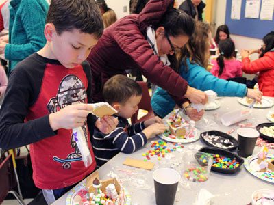 With nearly every candy imaginable, the children at the Wellesley Free Library work on decorating gingerbread houses.