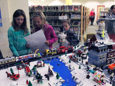 Wellesley Free Library visitors attempt to complete the entire ‘I Spy’ game that goes along with the LEGO Winter Village.