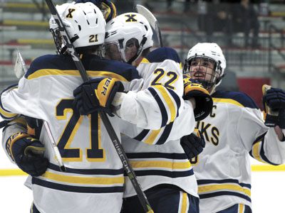 After cutting the deficit to 4-3 on the power play late in the second period, Xaverian defenseman Doug Concannon (21) celebrates with teammates Ryan Pompeselli (22) and Ross Vona (19).