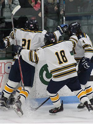Trent Kamke (4), Danny McEvoy (18), and Phil Pascucci (21) mob Tom Fachetti after his game-tying goal early in the second period. Photos by Michael Flanagan