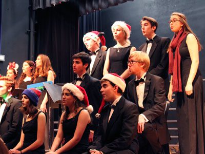 With Santa hats and festive props, Needham High’s Chorale performs ‘White Christmas’ at the annual winter concert.