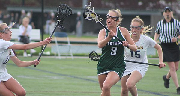 Needham’s Maeve Barker (15) and Elena Oberle (14) defend against Westwood’s Caroline Kremer (9) following a Westwood faceoff victory early in the first half. Photos by Michael Flanagan