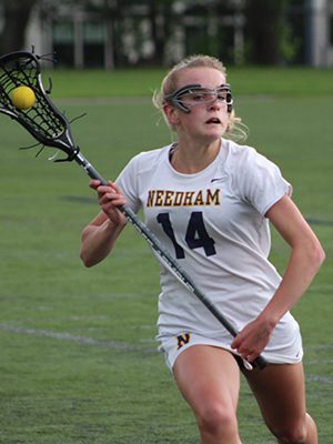 Elena Oberle (14) tip toes the sideline and rushes the ball up the field for Needham early in the first half. Photos by Michael Flanagan