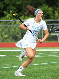 Medfield senior captain Maggie McCarthy (15) makes a break for the cage off of transition early in the first half against Watertown on Tuesday. Photos by Michael Flanagan