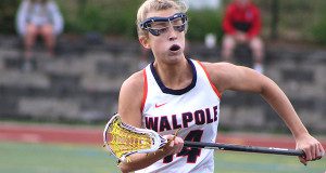 Senior captain and Villanova-bound attacker Emily Curtis (14) hustles back on the ride and defends a Natick clearing attempt.