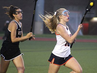 Walpole’s Erin Maloney (18) attempts to out run Wellesley’s Brooke Baker (1) on a rush up the field.