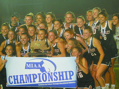 The Wellesley High School girls varsity lacrosse team poses with their Division I state championship banner and trophy after a thrilling 7-5 victory over Bay State Conference rival Walpole on Saturday at Boston University. Photos by Michael Flanagan