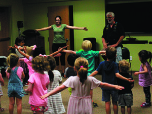 A volunteer from the crowd helps show dance moves to the kids as Norton plays the drums. Photos by Daniel Curtin