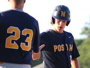 Steven Donovan (right) is given praise by his first base coach after an RBI single in the bottom of the fifth. Photos by Michael Flanagan
