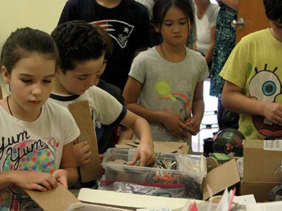 Youths used household items like cardboard, soap boxes, and CDs to build their cars. Photos by Daniel Curtin