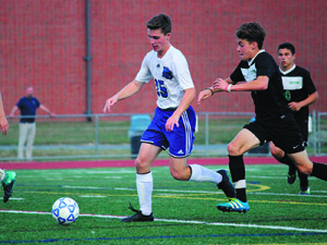 Defender Elliott Hammerness (15) wins a race to a loose ball during last year’s 3-0 season-opening win against Sutton. Photo by Michael Flanagan
