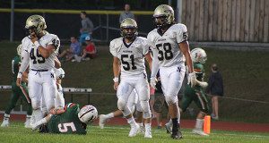 Senior captain and defensive end Jonah Kurker (58) celebrates with teammates after his tackle forced a turnover on downs late in the first quarter.