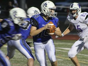 Junior quarterback Kirby Ryan (15) drops back in the pocket early in the second quarter of Friday night’s 9-7 victory over Norton.