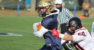Wellesley’s Trevor Foreman (50) attempts to wrap up Needham’s Tyler Reid (25) during this year’s Thanksgiving tilt.