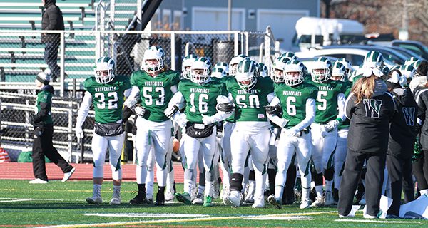 From left-to-right: seniors Dominic Hough (32), Miles Heespelink (53), Eli Maroun, Declan Burke (50), and Braden Loughnane (6) lead the Wolverines out onto the gridiron. Photos by Mike Mao