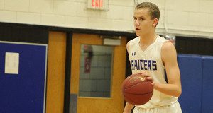 Senior captain and guard John Muckstadt (5) moves the ball up the floor midway through the first quarter.
