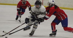 Senior captain Lexi Schmalz (17) fights off a stick check and carries the puck into the offensive zone on a rush up the ice.